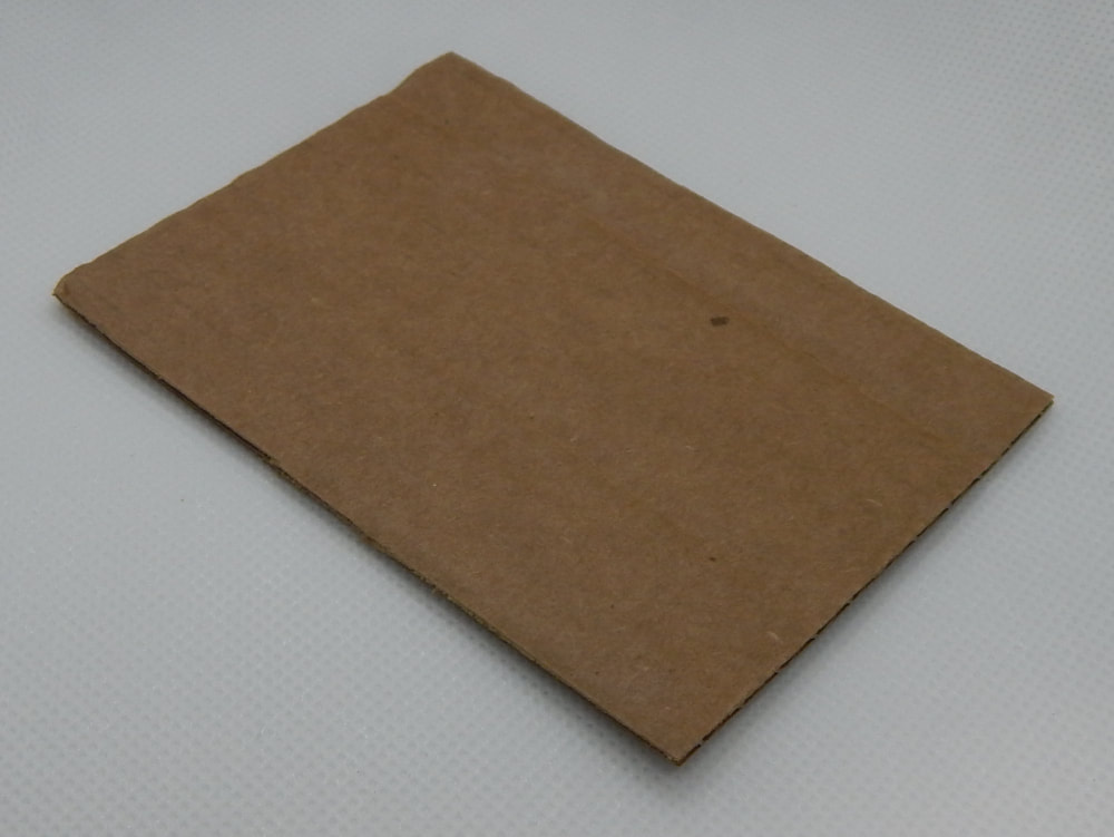 A rectangle piece of brown corrugated cardboard