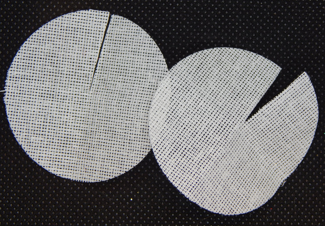 Two circles of stiff woven white fabric with a slit cut from the edge to the middle