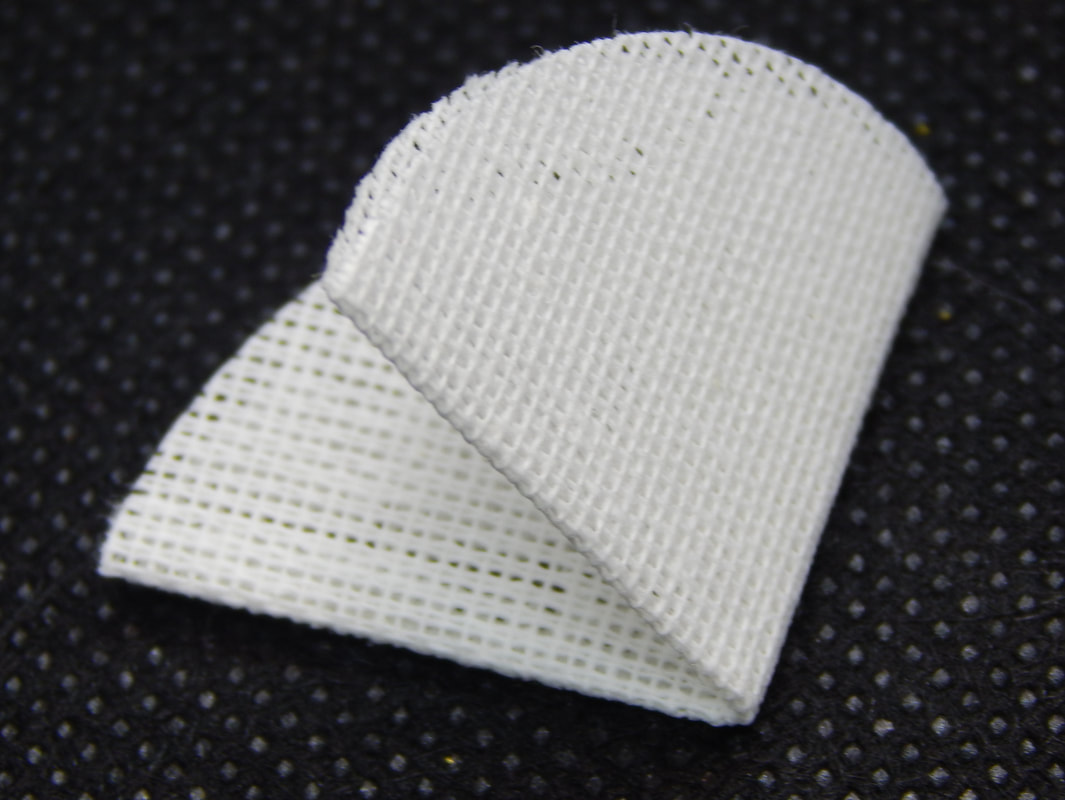 A piece of stiff white textured woven fabric cut in a circle and folded into quarters