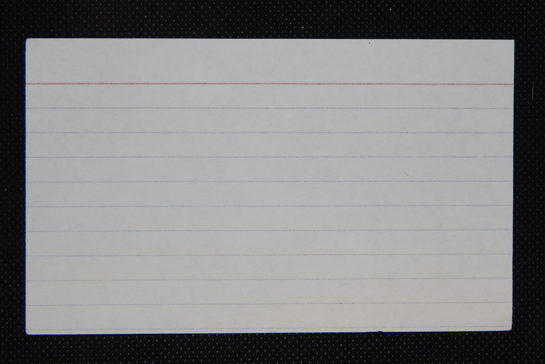 A white lined index card on a black background