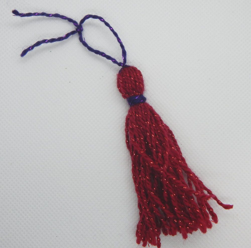 A red and purple tassel is tilted to the left. There is a 6 and 7 in the upper right hand corner of the picture.
